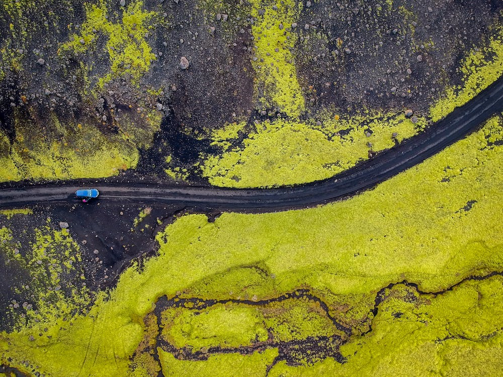 Aerial Photography of Blue Vehicle on Road in Iceland
